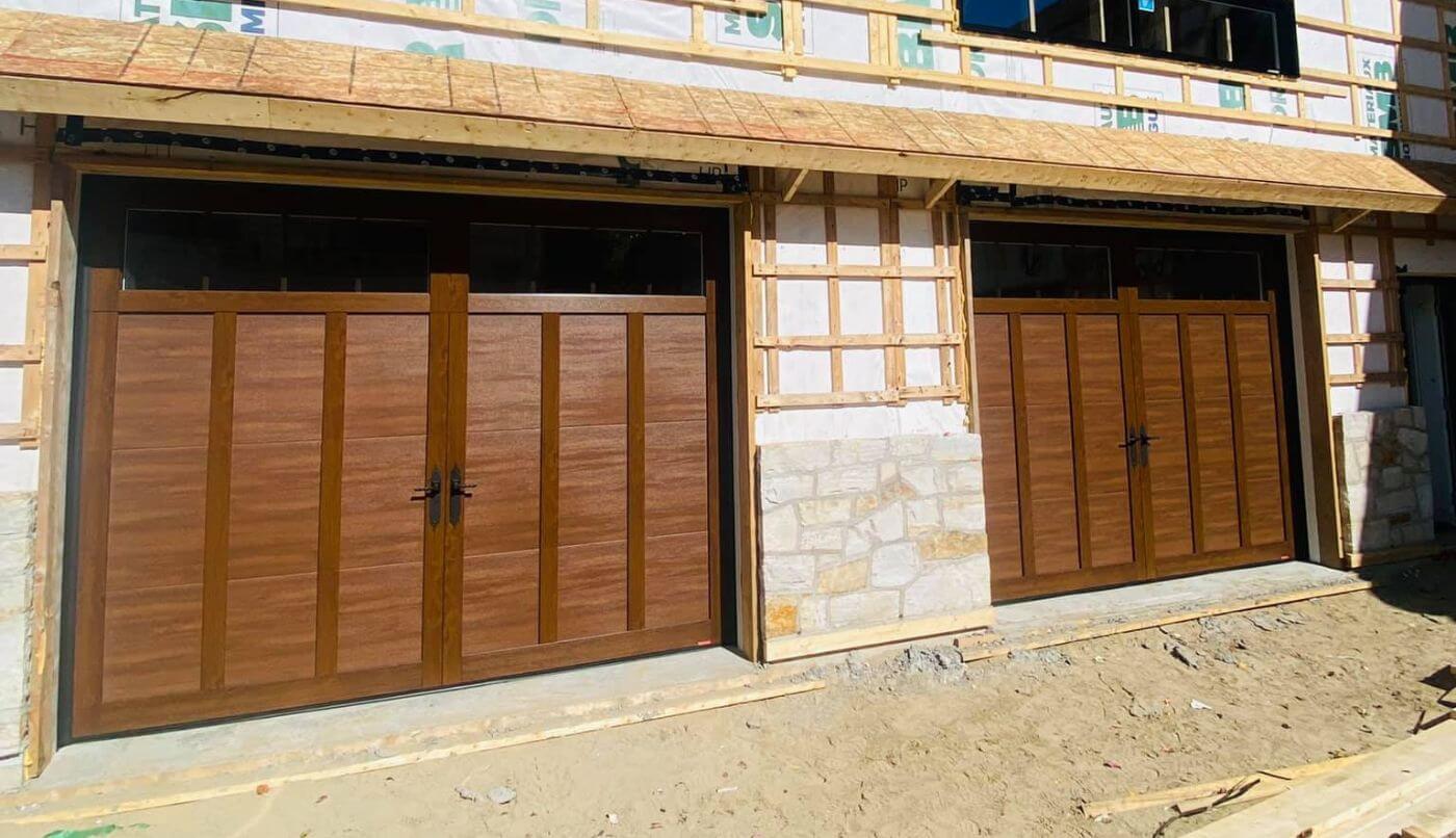 Installation de deux portes de garage sur une maison, soulignant l'amélioration esthétique et fonctionnelle de l'habitat.