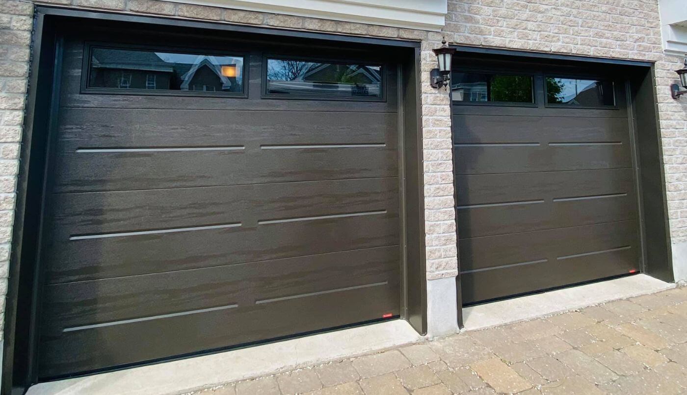 Deux portes de garage avec des fenêtres, offrant un aspect élégant et moderne à la façade.