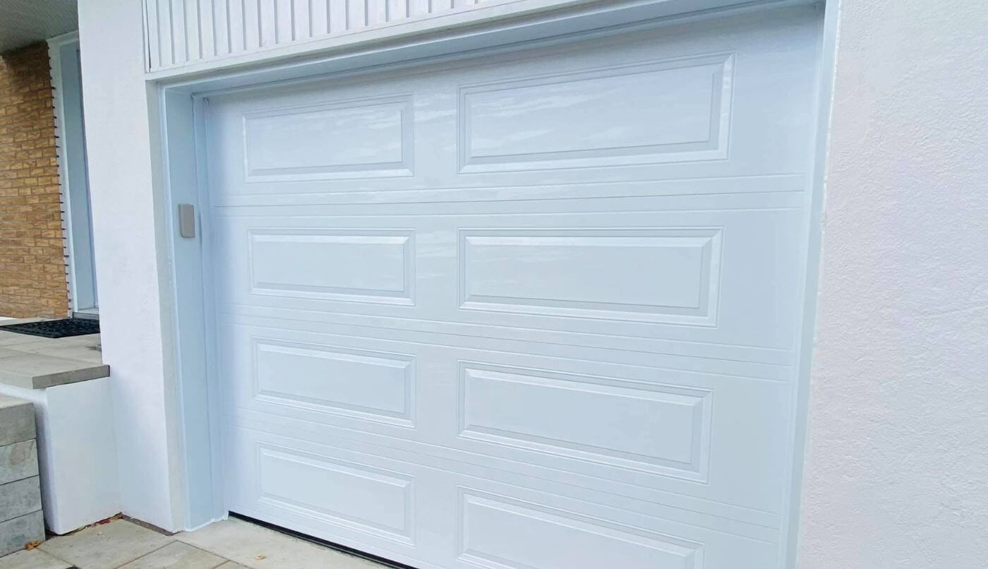 Une porte de garage blanche, offrant une apparence harmonieuse et épurée.