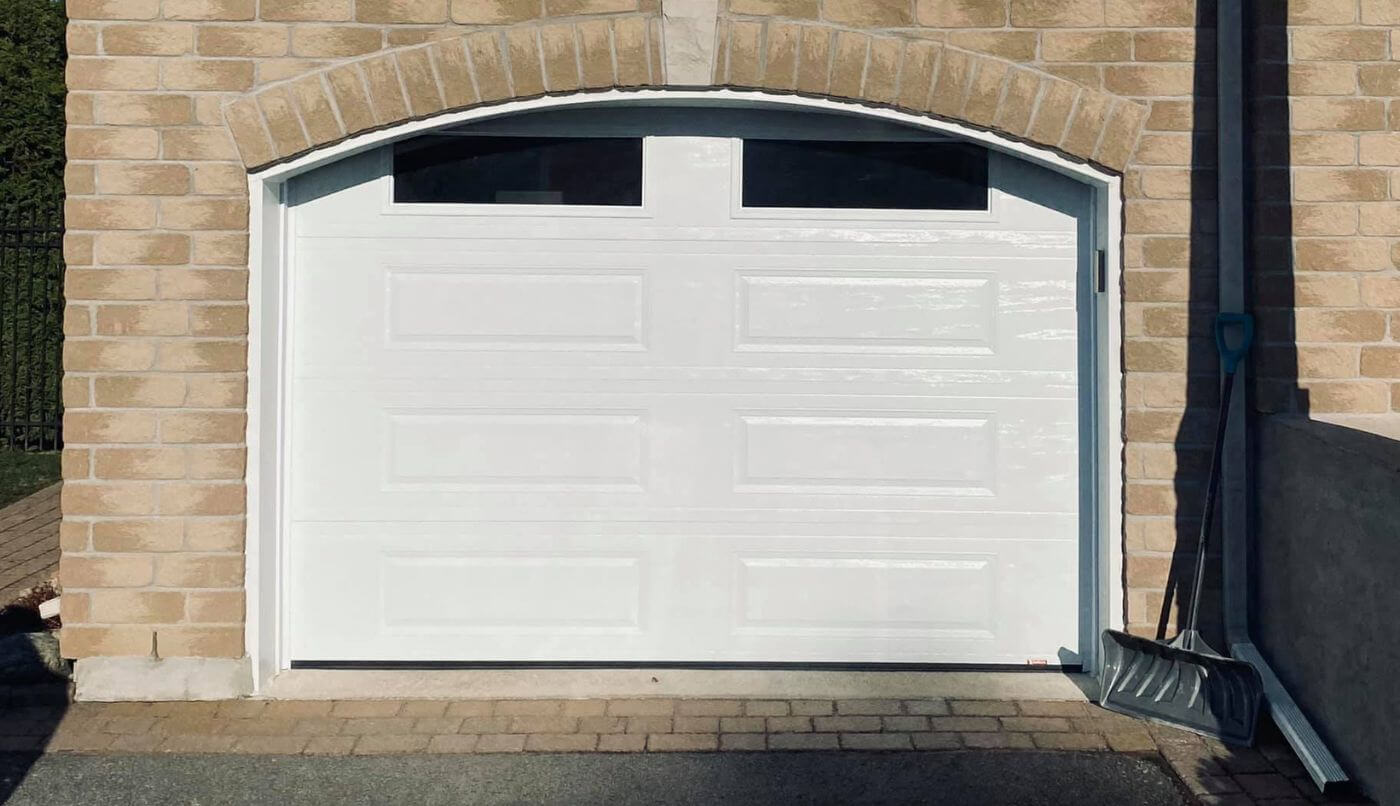Garage avec une porte blanche, créant une façade élégante et uniforme.