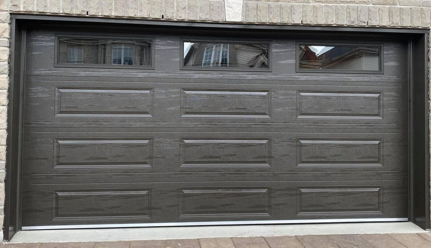 Une porte de garage offrant un aspect élégant et chaleureux à l'extérieur d'une maison.
