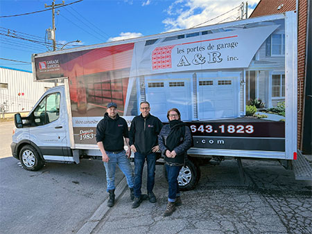 The great team from Portes de garage A & R inc. in front of their beautiful truck