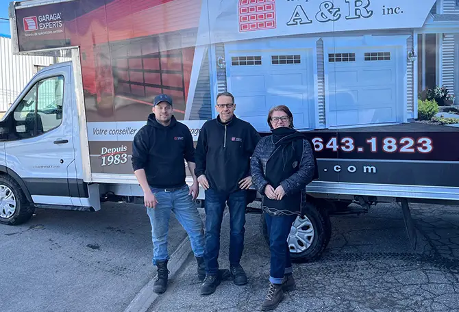 The team at Portes de garage A &amp; R inc. in front of one of their service truck.